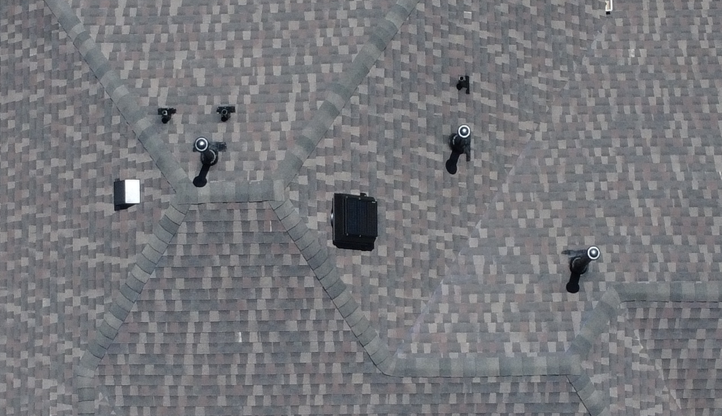 Asphalt roof with a solar attic fan near the ridge